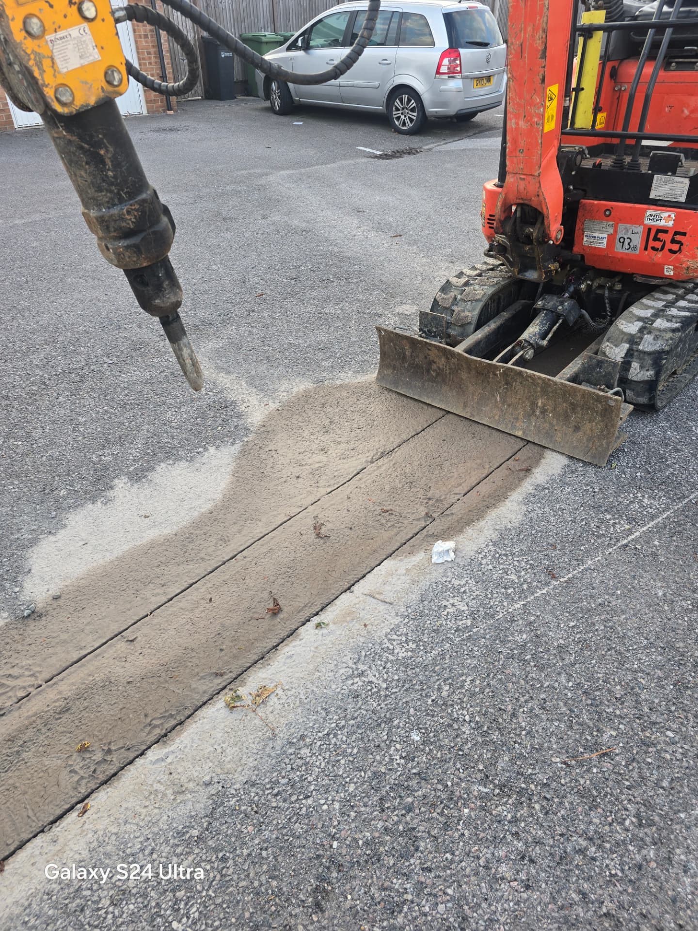 Hydraulic breaker on an excavator starting to break out hardstanding in Portsmouth