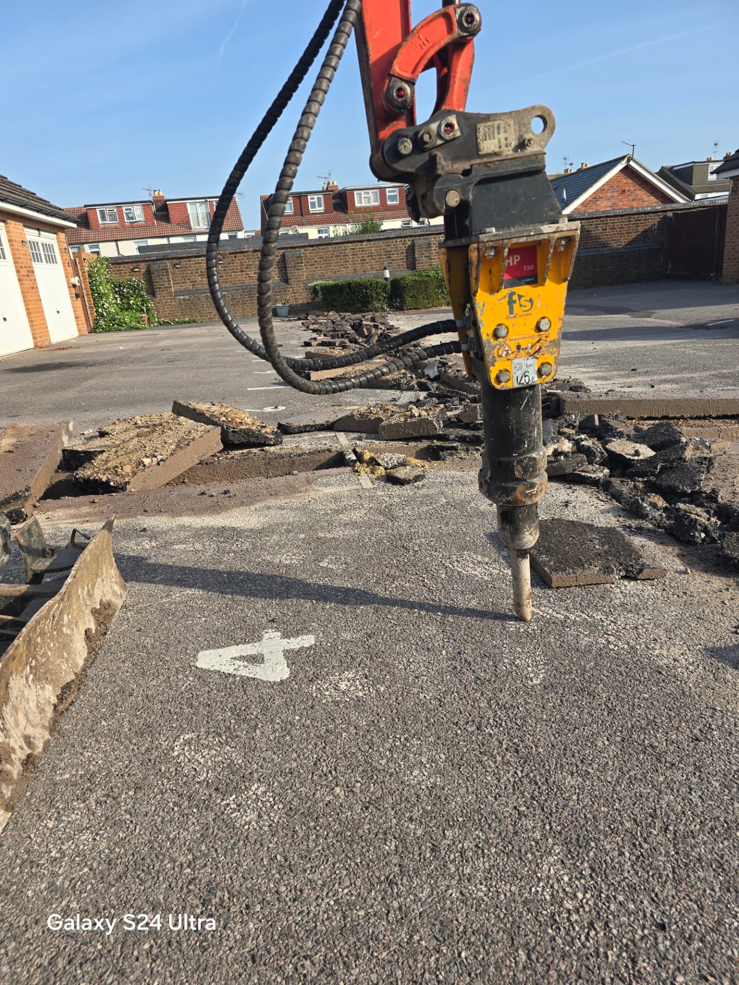 Operator using excavator-mounted hydraulic breaker to open a cable route in Portsmouth