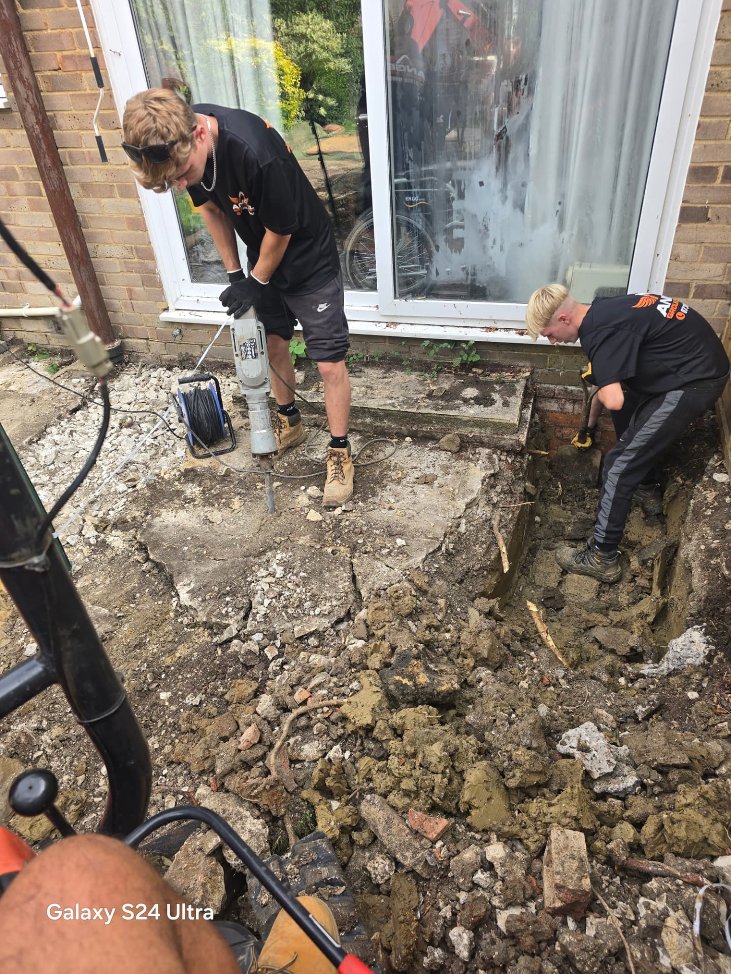 Breaking up old concrete with a breaker during groundworks in Lewes