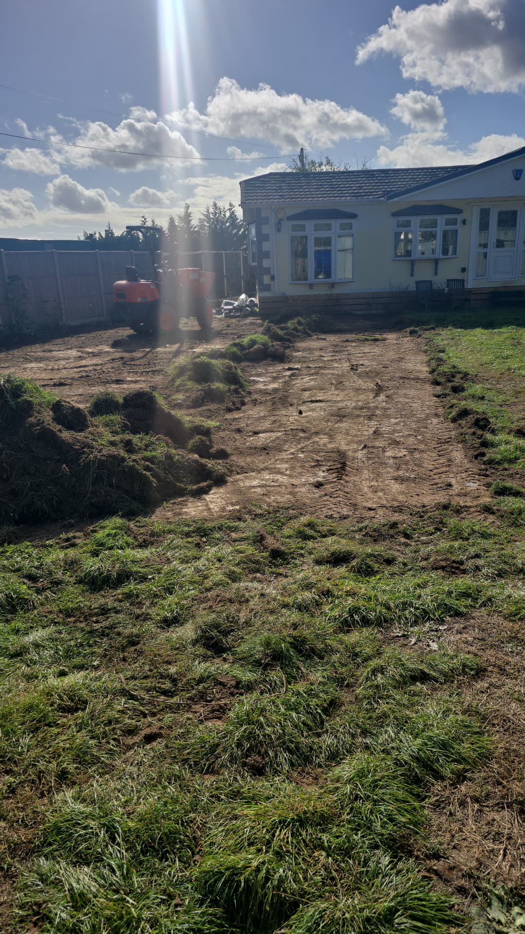 Tracked dumper beside a property with stripped turf and exposed ground during site preparation near Emsworth